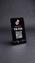 Black TikTok follow stand with QR code and tap instructions